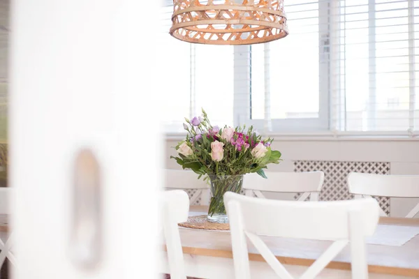 Acogedor comedor interior con decoración de flores en una habitación blanca de una casa moderna de cerca —  Fotos de Stock