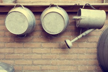 Metal sulama tenekeleri tuğla duvar bahçe tarafından