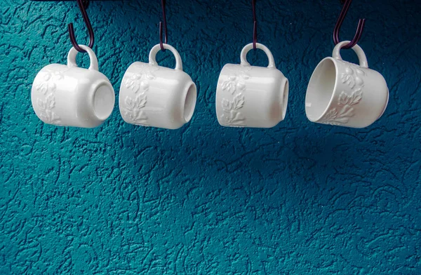 Tazas de café colgando en ganchos de la pared de la cocina azul interior moderno — Foto de Stock