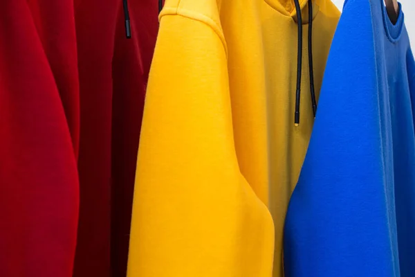 Hoodies coloridos em cabides close-up design moderno — Fotografia de Stock