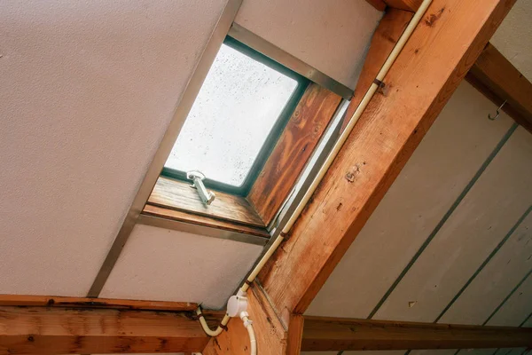 Attic, roof before construction with window and wooden beams — Stock Photo, Image