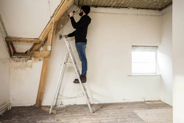 Handyman Berdiri Atas Tangga Dan Merenovasi Rumah Menggunakan Alat Alat — Stok Foto
