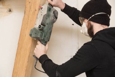 Tamirci bir ev tadilatı ayrıntılı zımpara ile çalışır