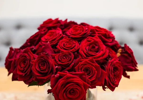 Red bouquet of red roses. Wedding flowers on gray background. Selective focus, valentine concept