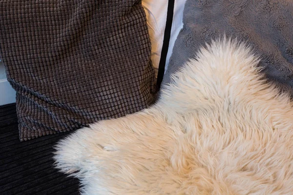 Bantal abu-abu di sofa menutup dengan selimut wol — Stok Foto