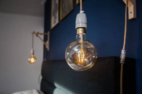 Bohlam lampu retro dekoratif dengan latar belakang dinding biru, desain modern — Stok Foto