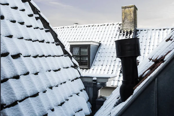 Pokryte śniegiem dachy budynków w mieście, zbliżenie, piękna zima — Zdjęcie stockowe