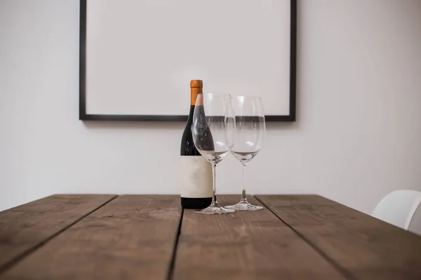 Bottle of wine and two glasses on a wooden table — Stock Photo, Image