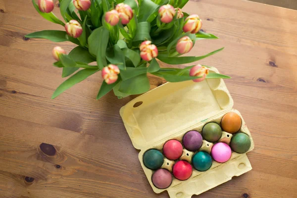 Barevné kraslice v poli na stole, Velikonoční dekorace — Stock fotografie