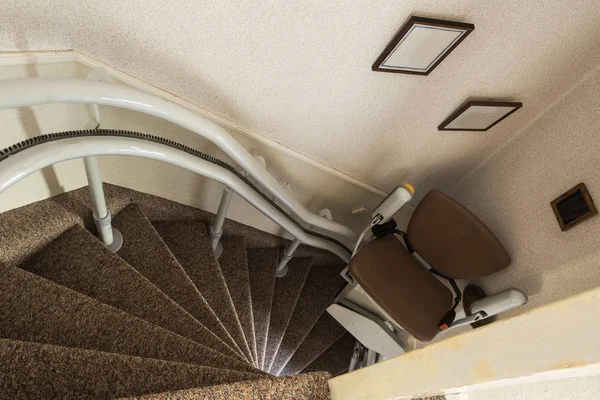 Mechanical chair lift taking disabled or aged people up and down stairs Senior, Stairlift for disabled — Stock Photo, Image