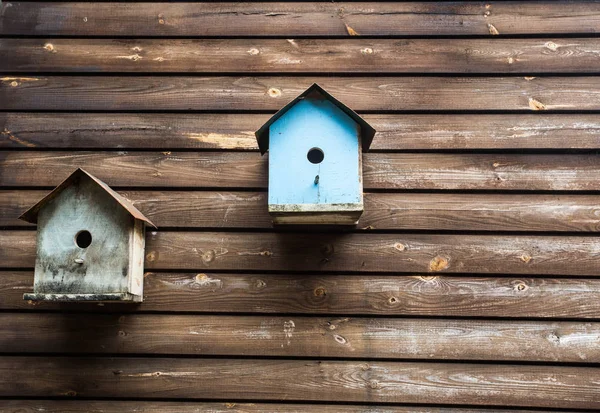 Drewniane skrzynki ptaków lub Birdhouses na drewnianej ścianie, tekstura tła — Zdjęcie stockowe