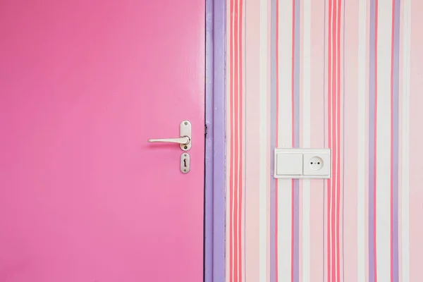 pink door with pink striped wallpaper closeup, girly design interior