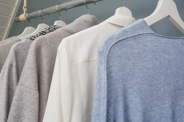 La ropa cuelga de un estante de ropa, blanco gris y azul , — Foto de Stock