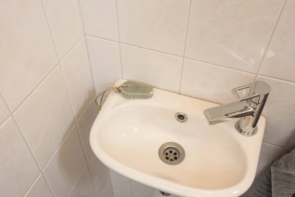 Tvättställ i badrum närbild, ny kran ren Stockfoto