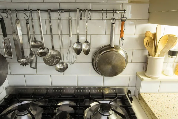 Кухонная посуда висит в уютной винтажной кухне над духовкой — стоковое фото