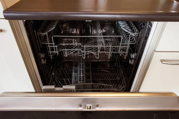 Современная полуоткрытая пустая посудомоечная машина на современной кухне — стоковое фото