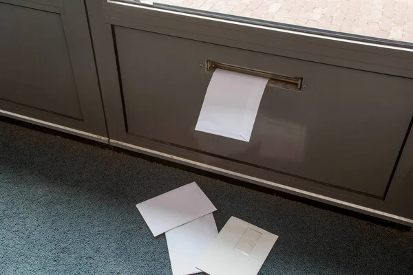 Posting tergeletak di lantai dan di kotak surat pintu di gedung kosong — Stok Foto