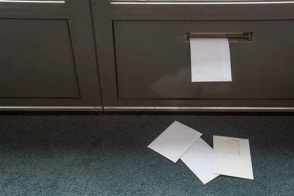 Posting tergeletak di lantai dan di kotak surat pintu di gedung kosong — Stok Foto