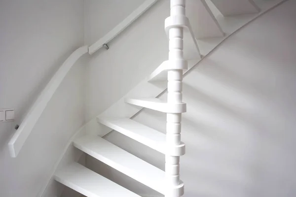 Stairs in modern white room, white wooden stairs with white wall