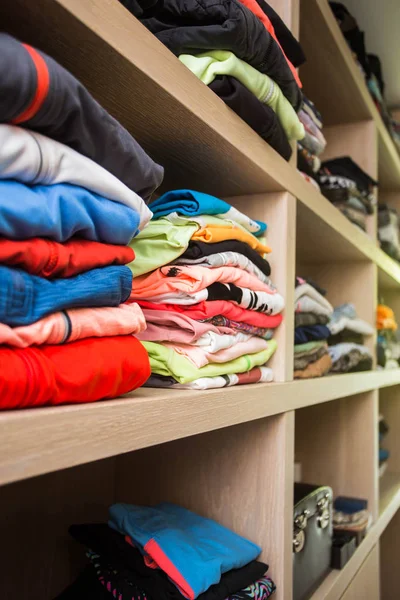 Åpen garderobe med masse foldede klær – stockfoto