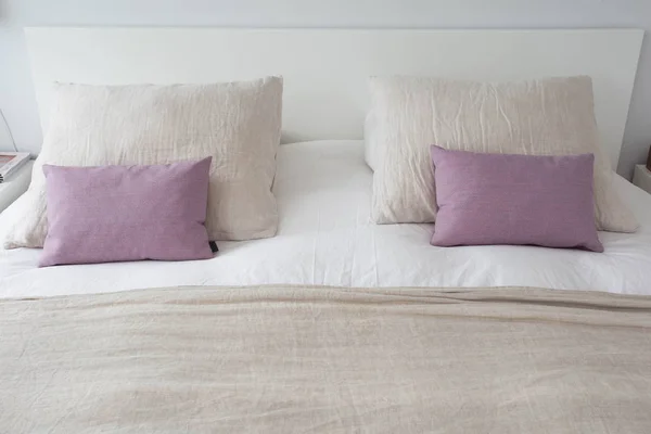Składa się pościel w nowoczesnej wygodnej sypialni z czystym białym narzutyną i poduszką z lekkim, czystym i jasnym wygodnym łóżkiem w sypialni z ciepłym światłem koncepcji, z bliska — Zdjęcie stockowe