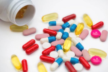 Çeşitli ilaç hapları, haplar, kapsüller ve beyaz arka planda bir şişe. Metin için alanı kopyala