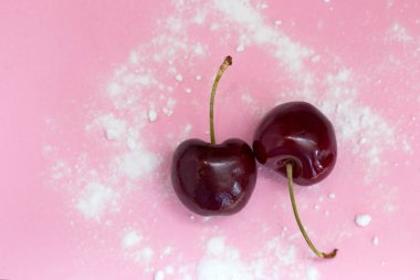 Pembe arka plan üst görünümü, sağlıklı konsept modern tasarım pudra şekeri izole iki kiraz