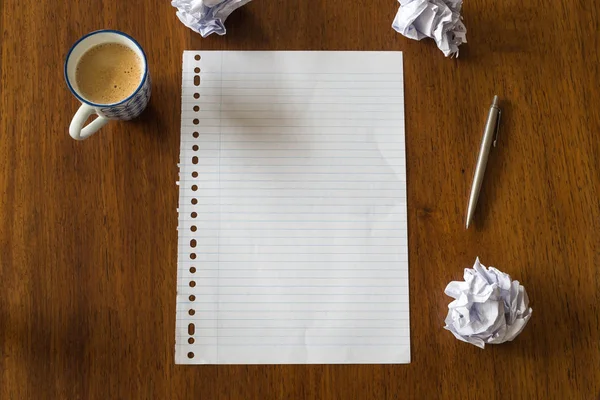 Pusty papier z długopisem i filiżanką kawy na drewnianym stole dla tekstu — Zdjęcie stockowe