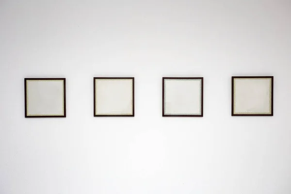 Blank black picture frame template for place image or text inside on the white wall in a row