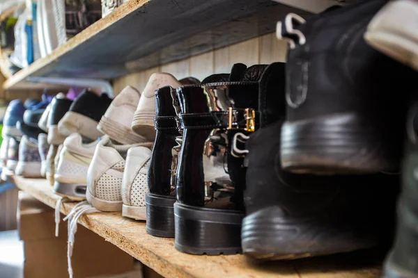 छोटे जूता रैक पूरी तरह से कई जूते, स्नीकर्स और सैंडल से भरा हुआ है। बहुत सारे जूते जूते रैक को गन्दा बनाते हैं। एक बेहतर फर्नीचर प्राप्त करने से आपका घर अच्छी तरह से व्यवस्थित हो जाएगा . — स्टॉक फ़ोटो, इमेज