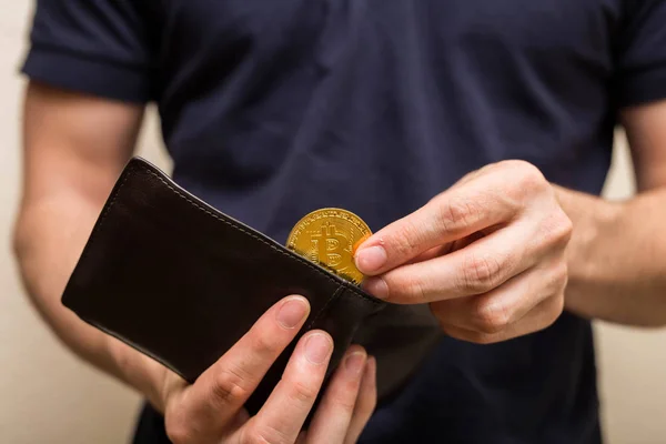 Ο άνθρωπος παίρνει χρυσό Bitcoin από το πορτοφόλι του, εικονικό νόμισμα. Κρυπτονόμισμα. Νέα εικονικά χρήματα. επιχειρηματίας άνοιξε το πορτοφόλι. — Φωτογραφία Αρχείου