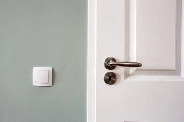 Modern white door with chrome door handle and light switch, new clean design — Stock Photo, Image