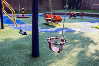 Şehirde renkli swingset ile boş çocuk oyun alanı