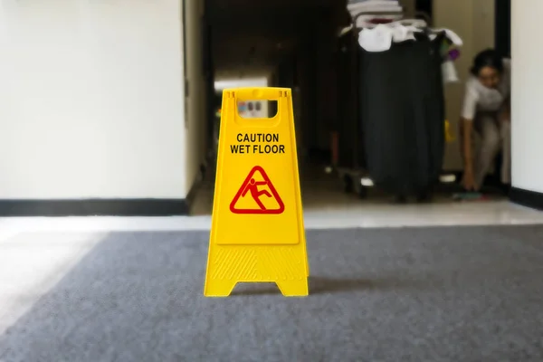 Skylt som visar varning för försiktighet våt golv, renare på bakgrunden — Stockfoto