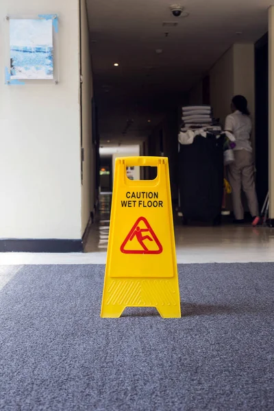 Εγγραφείτε που δείχνουν προειδοποίηση προσοχή βρεγμένο πάτωμα, καθαρότερο στο παρασκήνιο — Φωτογραφία Αρχείου