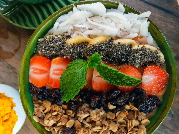 Organikus reggeli müzli joghurt, eper banánnal, chia maggal és kókuszdióval töltve — Stock Fotó