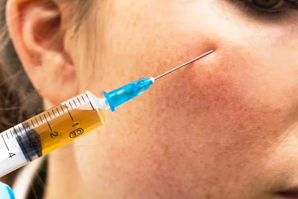 Vanlig kvinna på skönhetskliniken får botox injektion för att ta bort ögonrynkor Stockbild