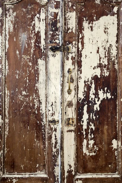 Old cupboard with cracked painted doors, texture of weathered cracked paint