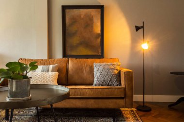 Kahverengi kanepesi ve boş tablosu olan modern bir oturma odası. Kahverengi kanepeli zarif bir retro tasarımı var.