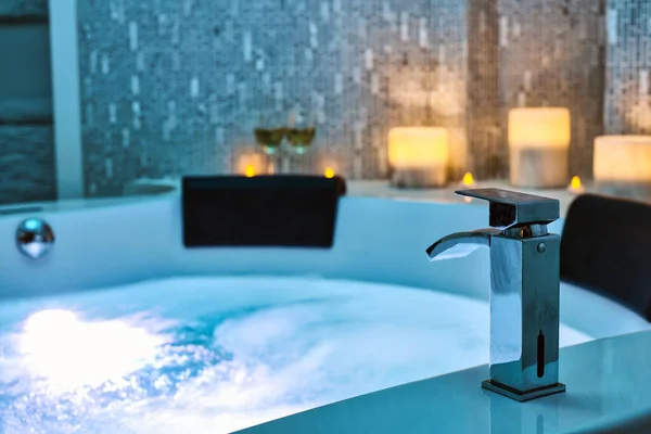 Blå bubblande Vatten i Spa Jacuzzi närbild kran dekorerad med ljus på bakgrunden, Koppla av och livsstil Abstrakt bakgrund med blå ljus — Stockfoto