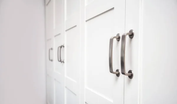 White wooden cupboard doors modern interior, storage or wardrobe closed with metal handles — Stock Photo, Image