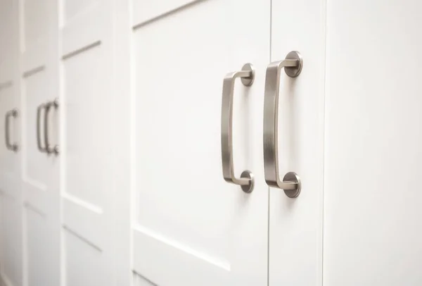 White wooden cupboard doors modern interior, storage or wardrobe closed with metal handles — Stock Photo, Image
