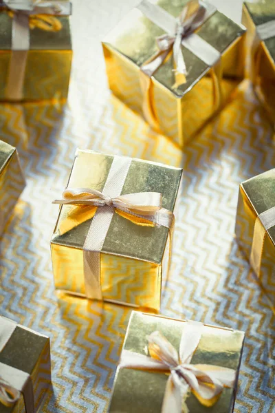 Group of gold sparkling gift boxes, beautiful gold packaging surprise with bow on sparkling background