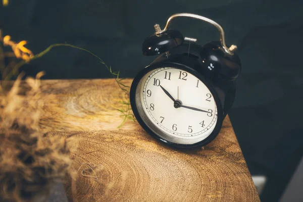 Relógio de alarme preto retro em suporte de noite de madeira, vintage ols scool design fundo — Fotografia de Stock