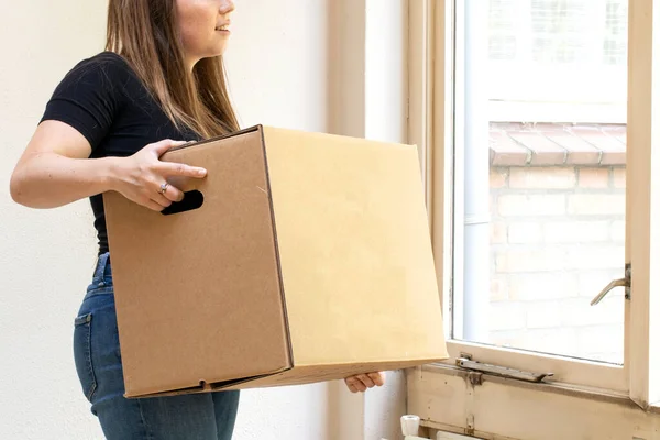 Mujer joven y feliz llevando una caja móvil de cartón para su nuevo hogar, mudanza o nuevo concepto de casa —  Fotos de Stock