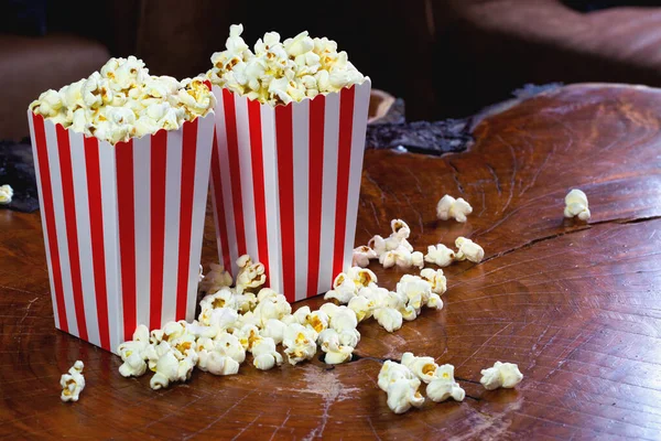 Palomitas de maíz en caja de cartón rojo y blanco retro rayado para cine sobre mesa de madera — Foto de Stock