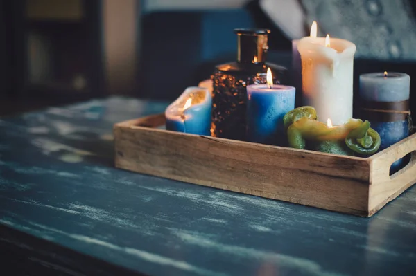 Διάφορα χρωματιστά κεριά σε ξύλινο τραπέζι στο σύγχρονο σπίτι, σε ξύλινο ρετρό κουτί, ζεστή διακόσμηση σε στυλ εσωτερικό — Φωτογραφία Αρχείου