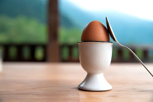 Huevo hervido en taza de huevo en la mesa de madera al aire libre, taza de huevo de huevo de clara de desayuno — Foto de Stock