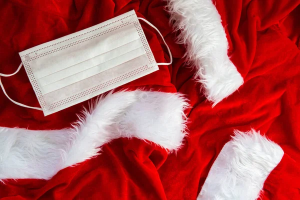Weihnachtsmann-Kostümstoff mit weißer Schutzmaske Hintergrundstruktur, Weihnachtskonzept und Covid-19-Konzept 2020, — Stockfoto