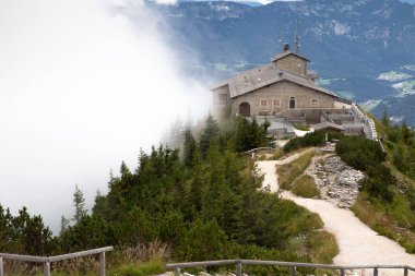 Kehlsteinhaus, Eagle Nest, Berchtesgaden Almanya, tarih güzel manzarayı sisli, bulutlu arkaplanlı dağ zirvesine yerleştirdi